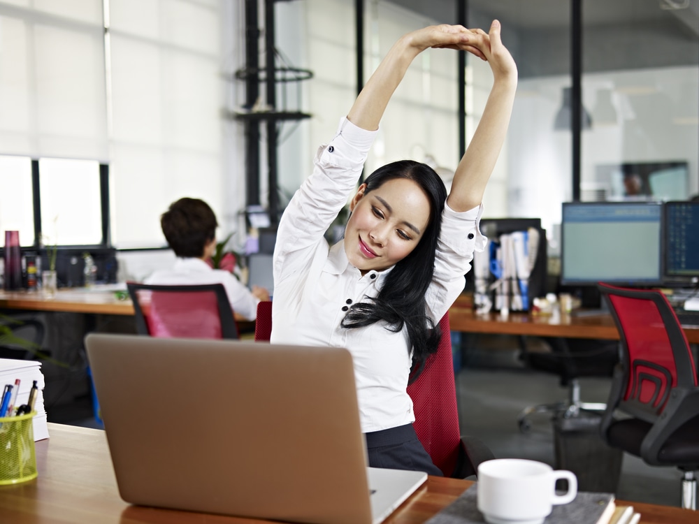 woman stretching at her work desk