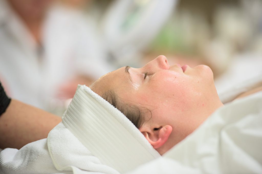 bellus student performing a facial on a client