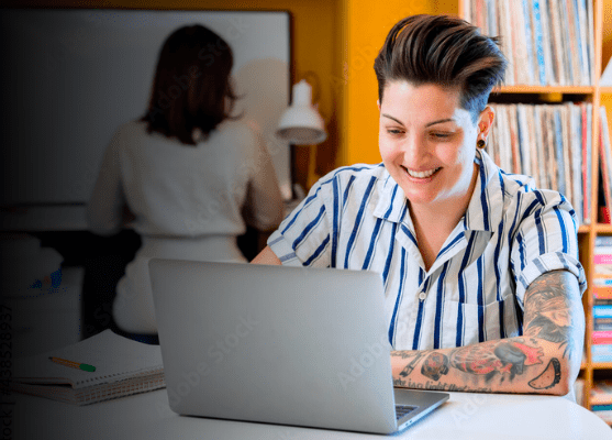 A smiling student working on a laptop.